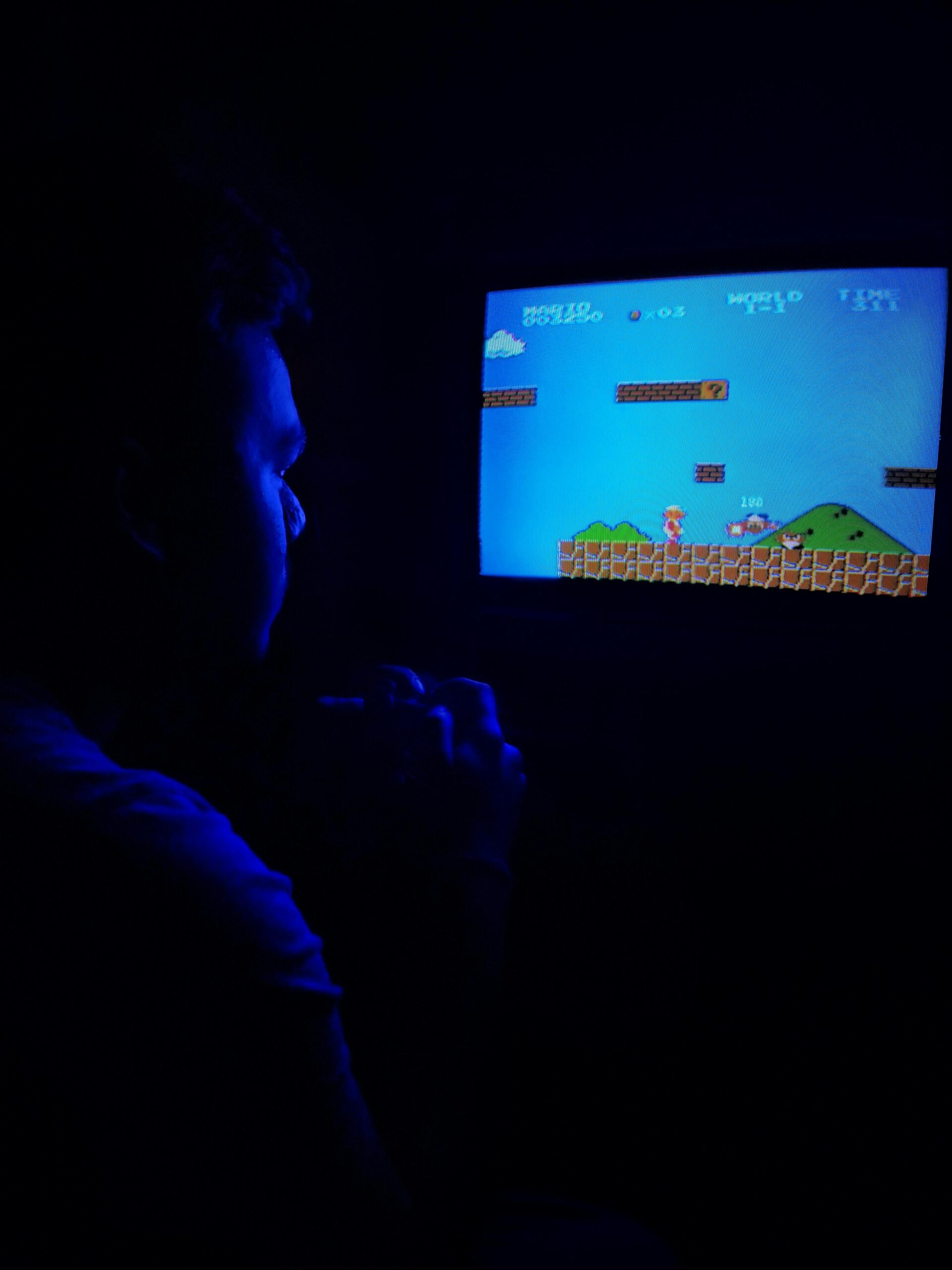 Man playing Super Mario Bros on TV, capturing retro gaming nostalgia. Man playing Super Mario Bros on TV, capturing retro gaming nostalgia.
